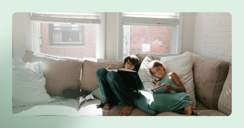 two young children acting like they can't do their homework to get help and attention